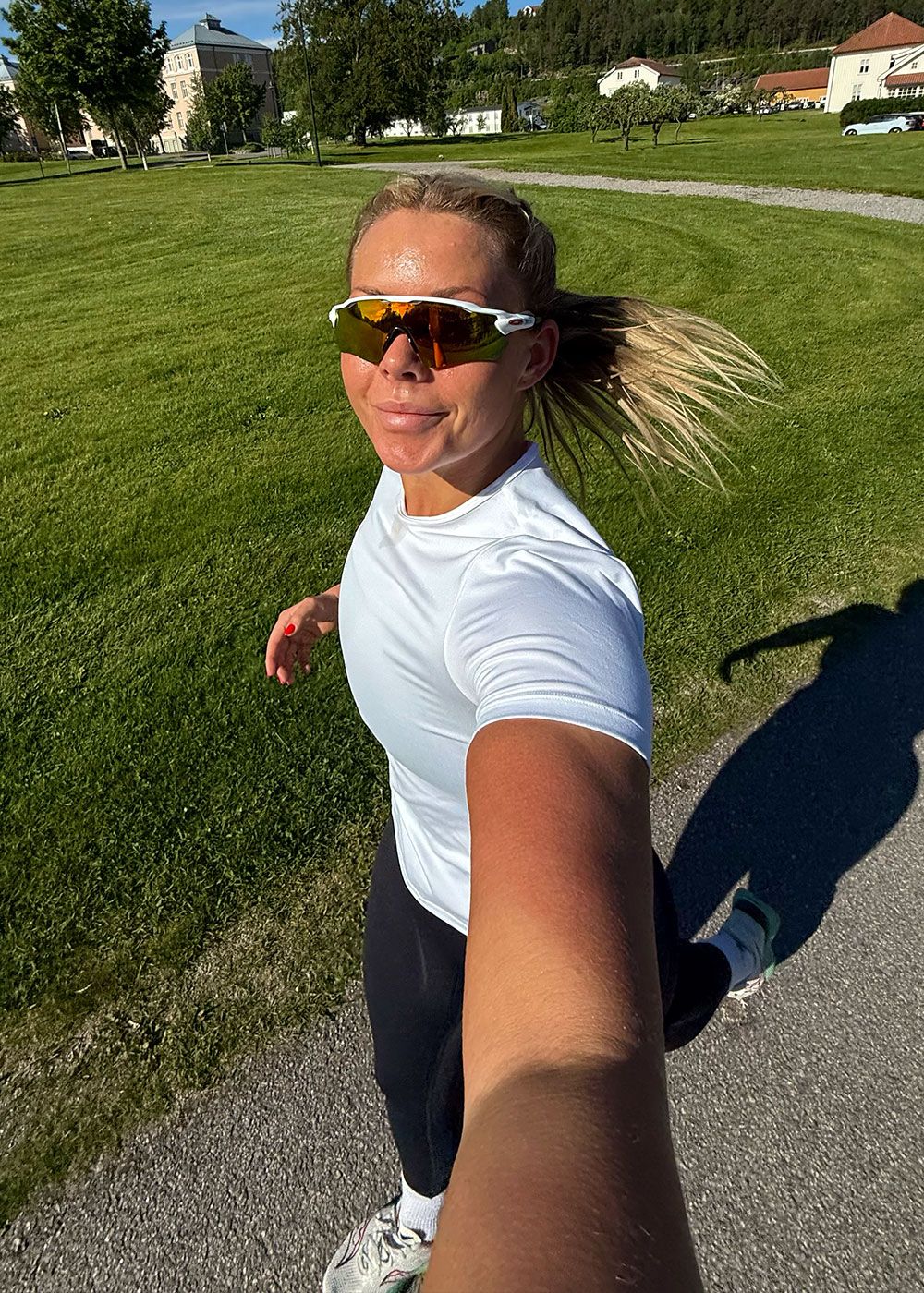 Coachen tar en selfie mens hun løper ute i solen